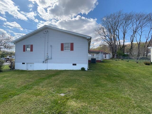 back of house featuring a yard, fence, and crawl space