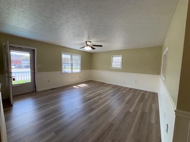 interior space with dark wood-type flooring, a textured ceiling, and plenty of natural light