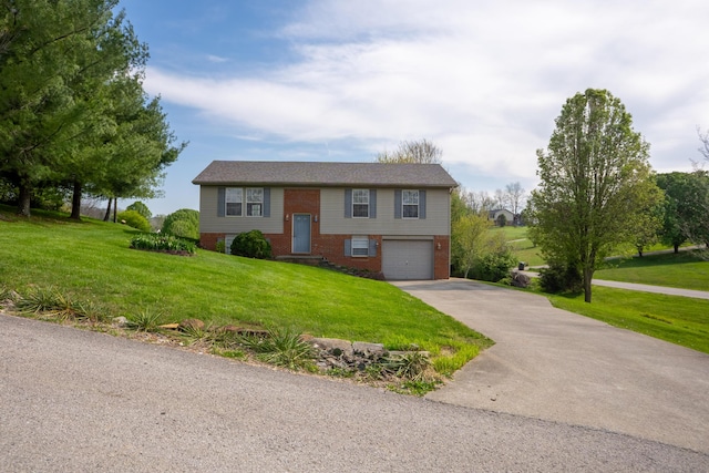 raised ranch with brick siding, a front yard, aphalt driveway, and a garage