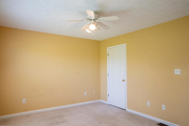 unfurnished room featuring baseboards, light colored carpet, and ceiling fan