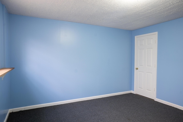 spare room with baseboards, carpet flooring, and a textured ceiling