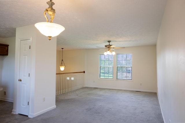unfurnished living room with carpet flooring, baseboards, a textured ceiling, and ceiling fan