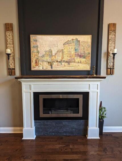 details with baseboards, wood finished floors, and a fireplace