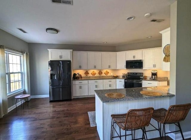 kitchen with visible vents, white cabinetry, black appliances, and dark wood-style flooring