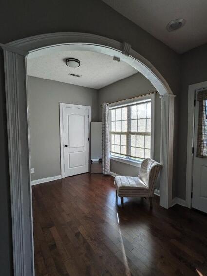 entryway featuring visible vents, baseboards, and wood finished floors