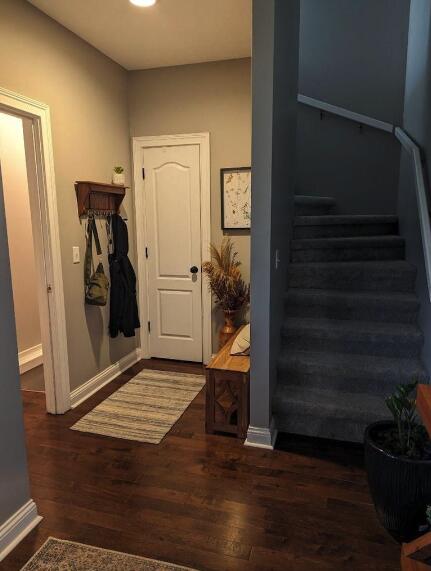 interior space with wood finished floors, baseboards, and stairs