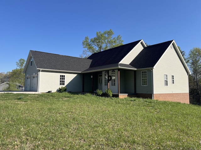ranch-style house featuring a front lawn, an attached garage, and roof with shingles