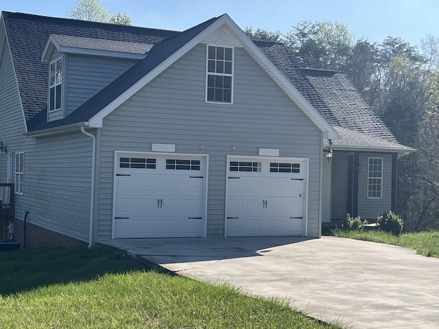 view of property exterior with a garage, driveway, and a shingled roof