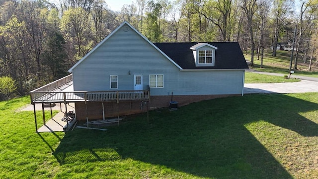 rear view of property featuring a yard, a deck, and central AC unit