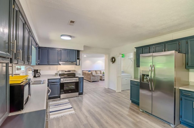 kitchen with light wood-style flooring, light countertops, under cabinet range hood, appliances with stainless steel finishes, and a sink