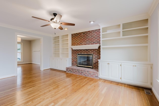 unfurnished living room with built in shelves, ceiling fan, ornamental molding, and light wood-type flooring