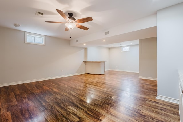 basement with baseboards, visible vents, and wood finished floors