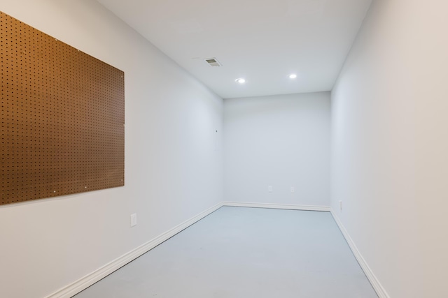 empty room featuring baseboards, recessed lighting, and finished concrete floors