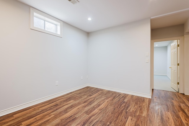 empty room with baseboards, recessed lighting, wood finished floors, and visible vents