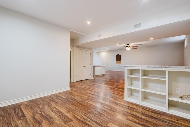 spare room featuring wood finished floors, a ceiling fan, recessed lighting, and baseboards