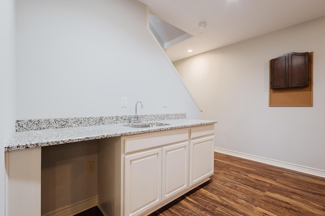 kitchen with recessed lighting, a sink, dark wood-style flooring, light stone counters, and baseboards