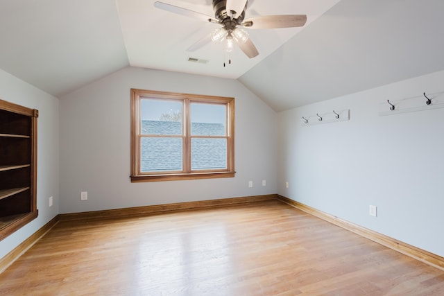 additional living space featuring visible vents, a ceiling fan, lofted ceiling, and light wood-style flooring