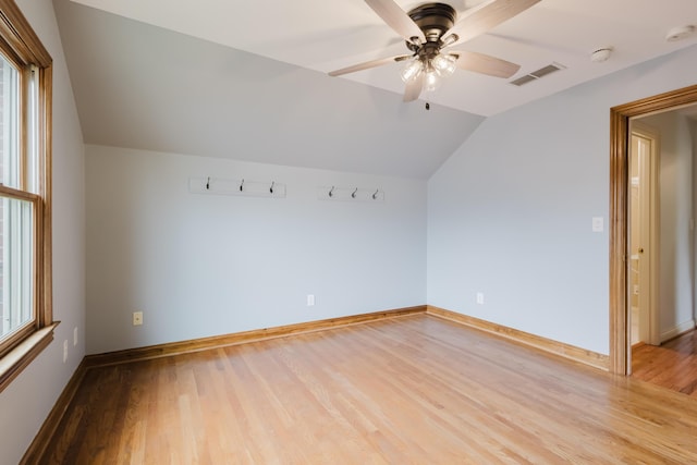 additional living space featuring light wood-type flooring, a ceiling fan, visible vents, baseboards, and lofted ceiling