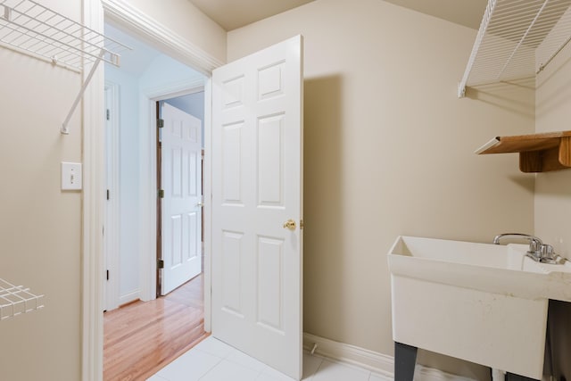 bathroom with tile patterned flooring, a sink, and baseboards