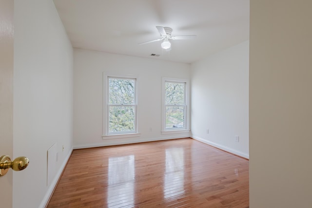 spare room featuring visible vents, ceiling fan, wood finished floors, and baseboards
