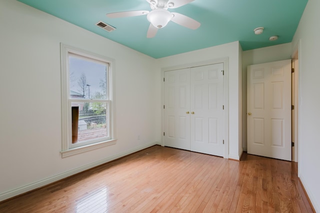 unfurnished bedroom featuring visible vents, baseboards, light wood-style flooring, and a closet
