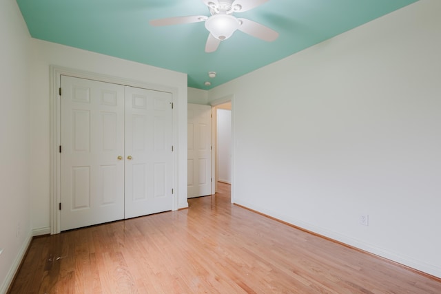 unfurnished bedroom featuring ceiling fan, light wood-type flooring, a closet, and baseboards