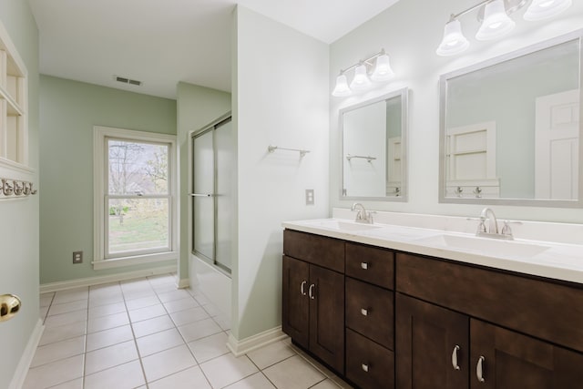 bathroom with baseboards, visible vents, tile patterned floors, and a sink
