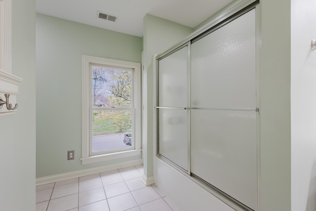 bathroom featuring tile patterned floors, visible vents, enclosed tub / shower combo, and baseboards