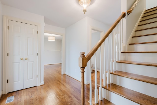 stairs featuring visible vents, wood finished floors, and baseboards