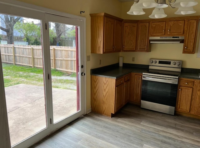115 Georgia St, Winchester, KY 40391 - kitchen with light wood-style flooring, stainless steel electric range oven, dark countertops, under cabinet range hood, and brown cabinetry