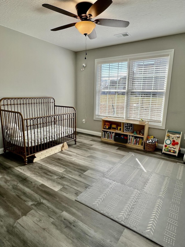 108 Allyson Cir, Junction City, KY 40440 - bedroom with ceiling fan, visible vents, wood finished floors, a crib, and baseboards