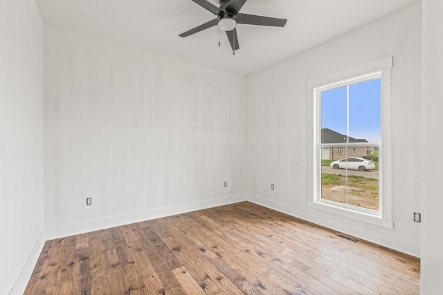 spare room featuring visible vents, ceiling fan, hardwood / wood-style floors, and baseboards