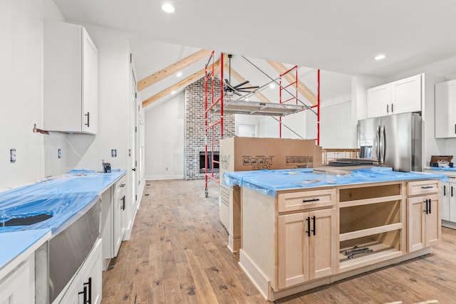 kitchen with recessed lighting, light wood finished floors, stainless steel refrigerator with ice dispenser, and lofted ceiling with beams