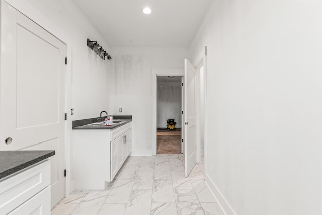 bathroom featuring recessed lighting, marble finish floor, baseboards, and a sink