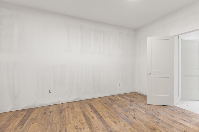 empty room with lofted ceiling and wood finished floors