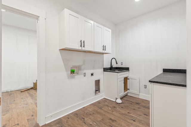 washroom with wood finished floors, hookup for an electric dryer, a sink, cabinet space, and washer hookup