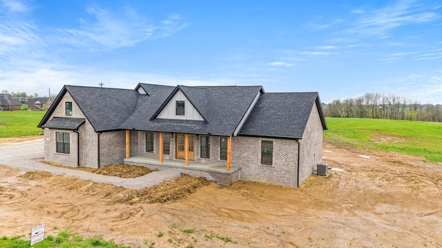 modern farmhouse with central air condition unit, roof with shingles, and brick siding