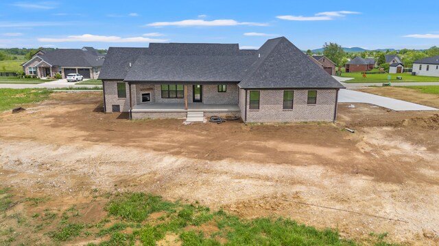 215 Berkley Hall Dr, Berea, KY 40403 - view of front of house with a porch, brick siding, roof with shingles, dirt driveway, and a residential view