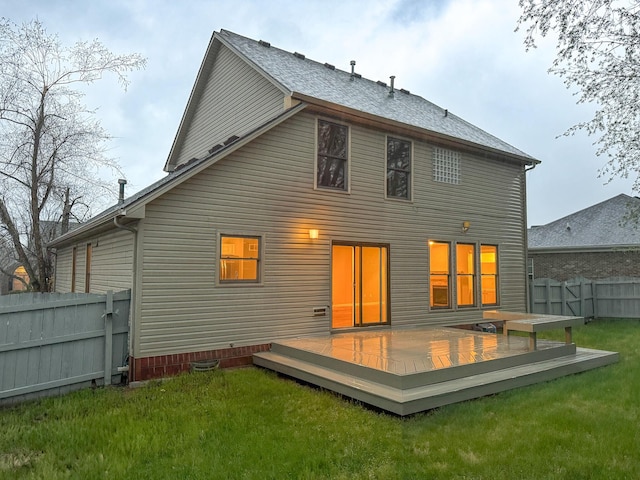 back of property featuring a lawn, fence, and a deck