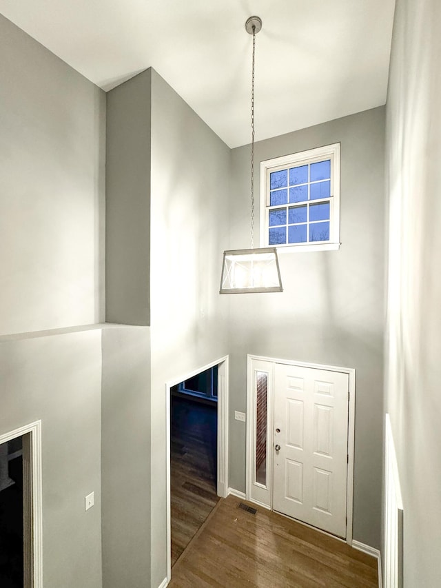 entryway with baseboards, wood finished floors, and visible vents