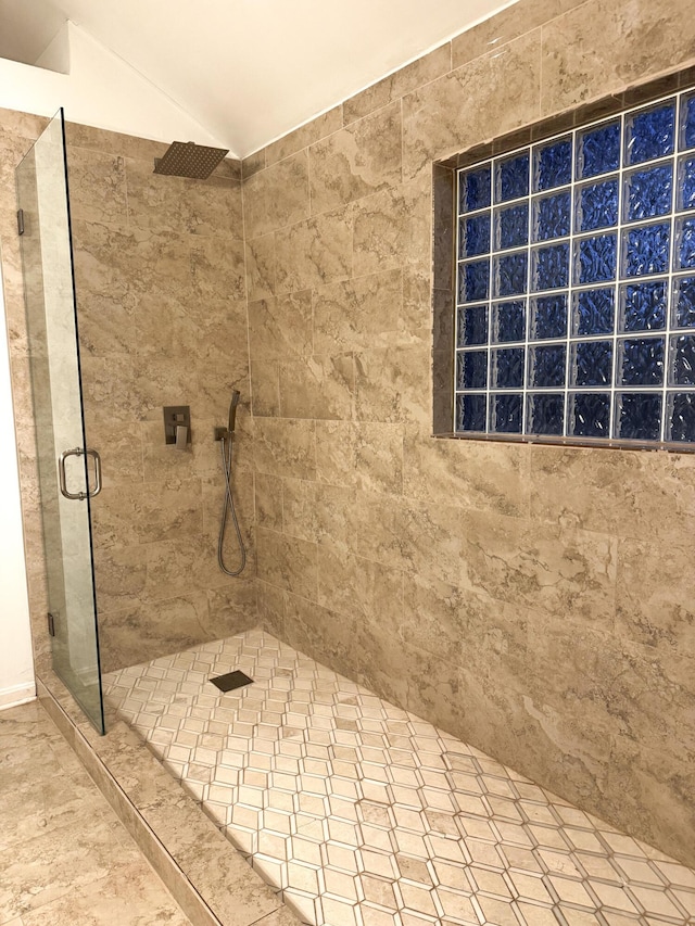 full bath featuring lofted ceiling and a stall shower