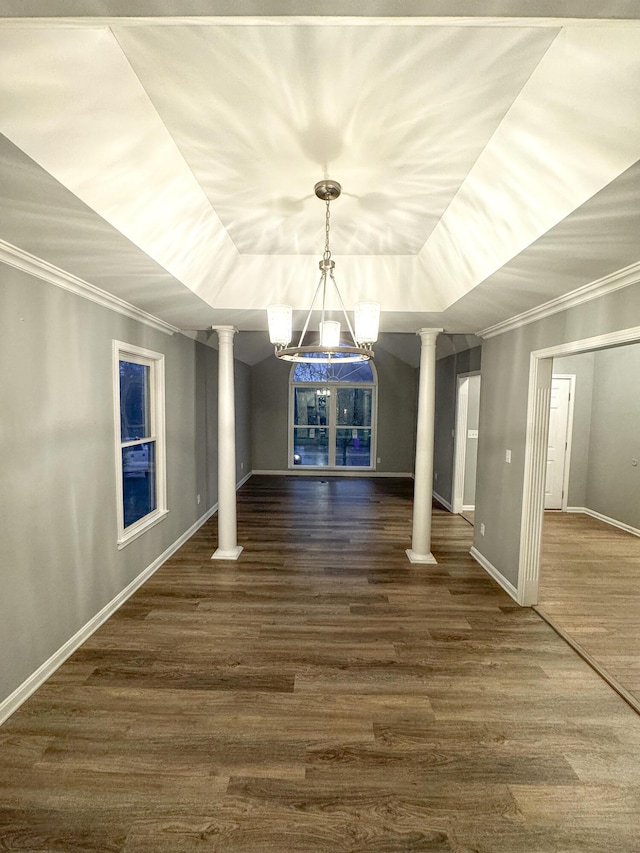 unfurnished dining area with dark wood finished floors, crown molding, and decorative columns