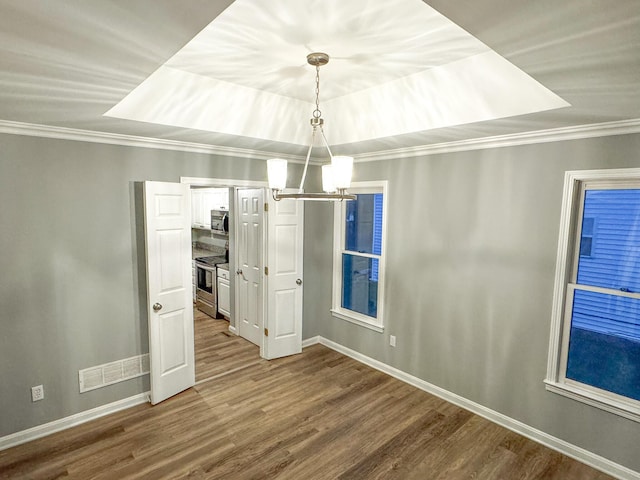 unfurnished dining area with dark wood-style floors, crown molding, an inviting chandelier, baseboards, and visible vents
