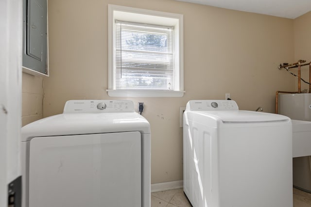 laundry area featuring washing machine and dryer, light tile patterned flooring, electric panel, laundry area, and baseboards