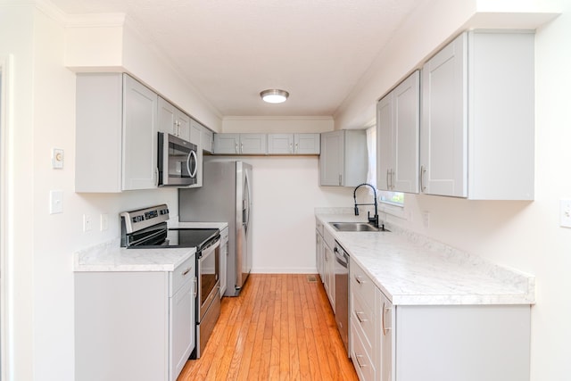 406 Kenway St, Berea, KY 40403 - kitchen with light countertops, a sink, light wood-type flooring, gray cabinetry, and appliances with stainless steel finishes