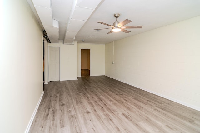 406 Kenway St, Berea, KY 40403 - empty room with concrete block wall, light wood finished floors, and ceiling fan