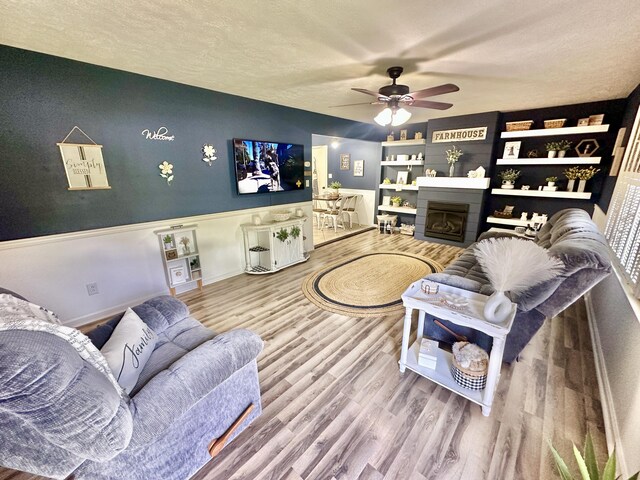 1870 Rush Branch Rd, Somerset, KY 42501 - living room with a textured ceiling, wood finished floors, ceiling fan, and a fireplace
