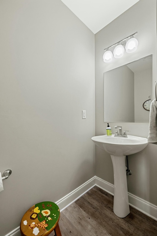 bathroom with wood finished floors and baseboards
