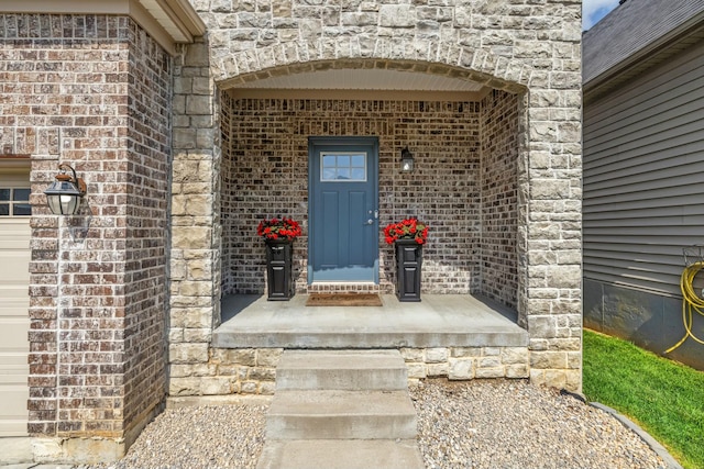 view of exterior entry featuring brick siding and stone siding