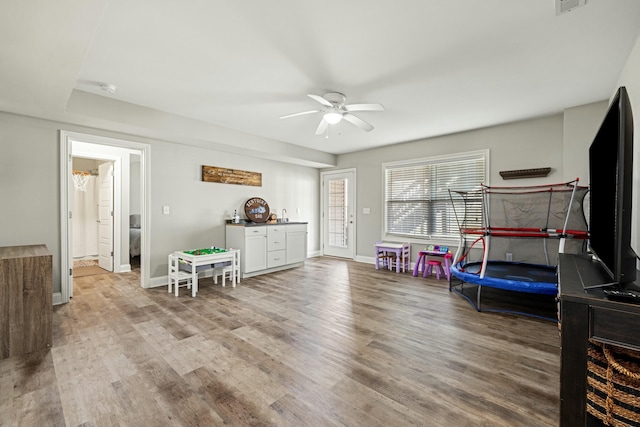 game room with baseboards, a ceiling fan, and wood finished floors